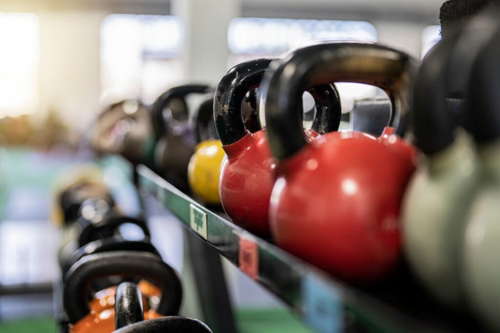 Atleta entrenando farmers carry Hyrox con dos kettlebells
