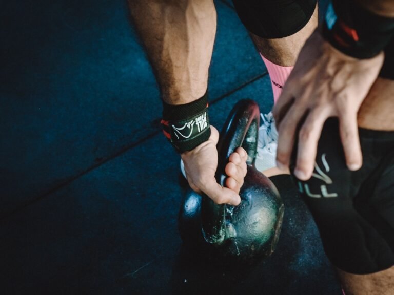 Atleta entrenando el agarre para Hyrox sujetando kettlebells en un farmers carry
