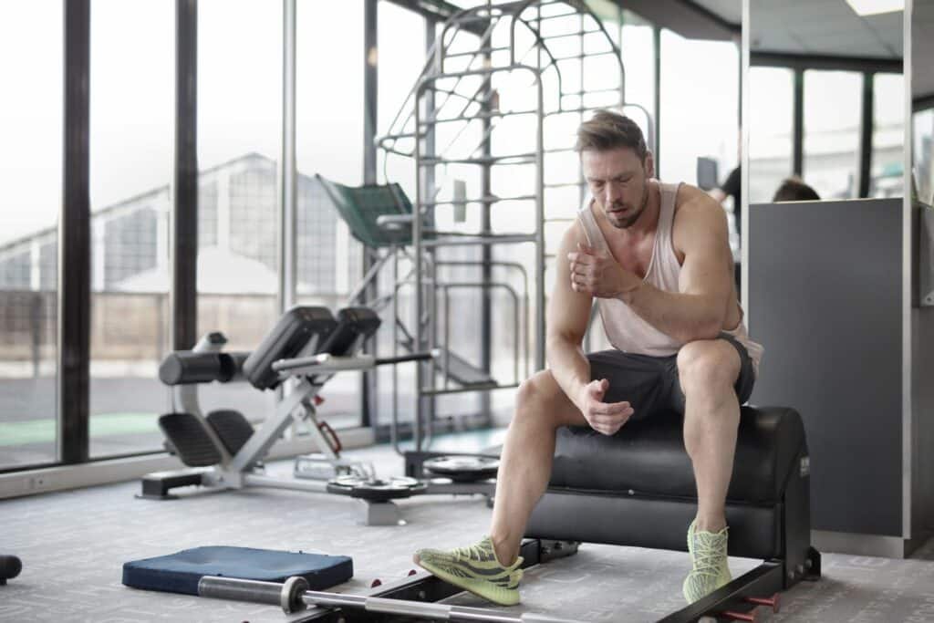 Atleta agotado por la fatiga muscular en el gimnasio, factor clave en los calambres en Hyrox