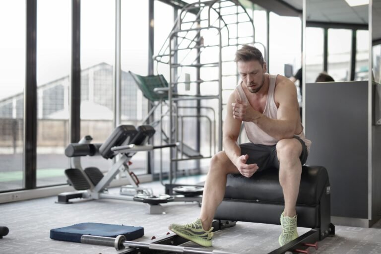 Atleta agotado por la fatiga muscular en el gimnasio, factor clave en los calambres en Hyrox