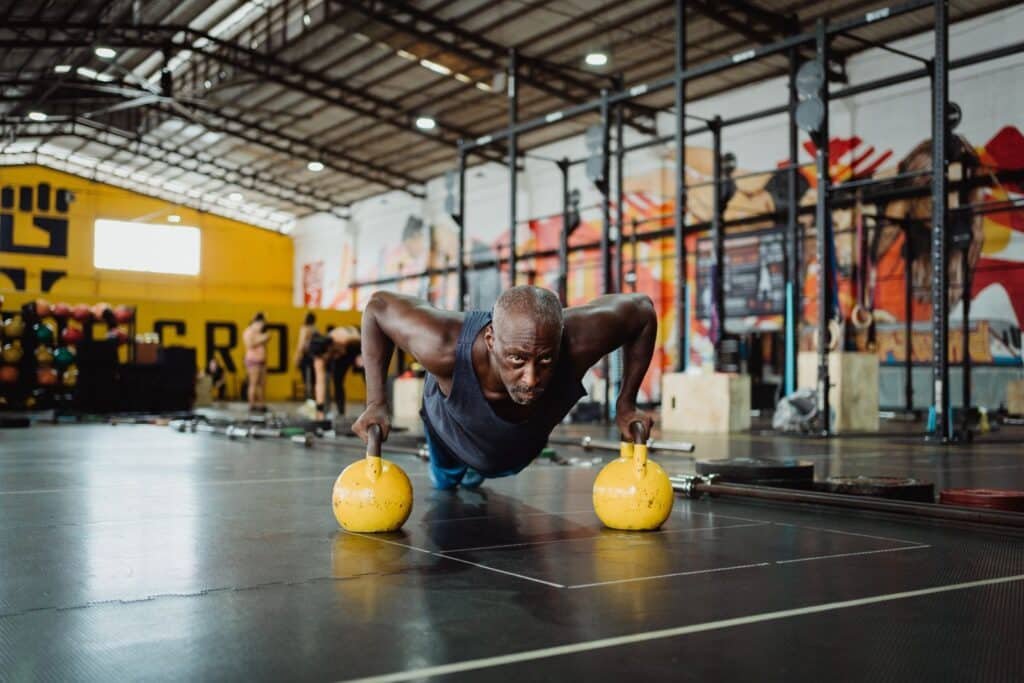 Atleta entrenando con kettlebells en un gimnasio funcional, la vía para preparar HYROX desde Zaragoza mientras la ciudad no tiene carrera oficial